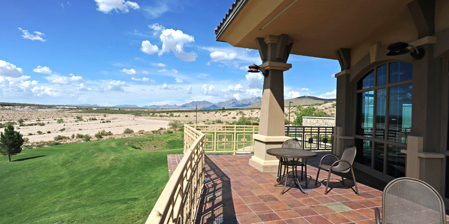 Panoramic view from the balcony patio at the Golf Clubhouse overlooking a vast desert landscape with the mountains in the distance.
