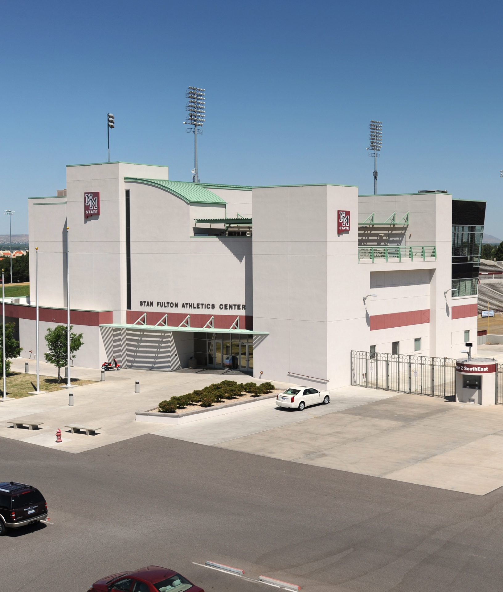 Exterior view of the Stan Fulton Athletics Center with clear blue skies and parking area.